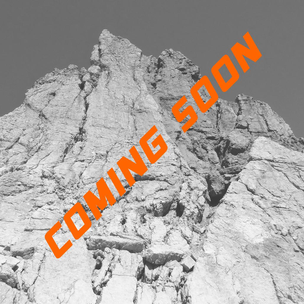 Das Bild zeigt im Hinterund schwarz weiß einen felsigen Berggipfel. Die Strucktur ist stark zerklüftet. Eine orangene Schrift durchzieht das Bild welche - COMING SOON - aussagt. 